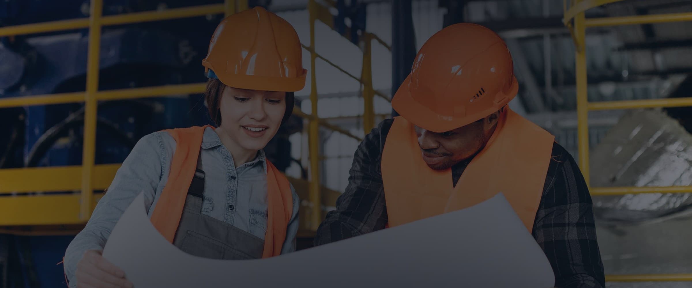 Two colleagues reviewing drawings together on site